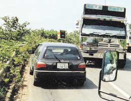 写真：車同士がやっとすれちがえる急で狭い県道。