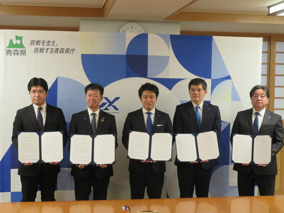 写真：協定書を手に記念撮影する代表者５名