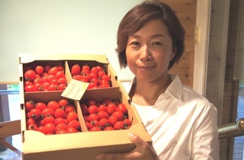トマトを持つ栗谷川柳子さん